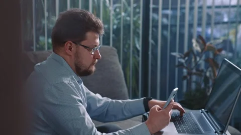 Man checking data between smartphone and laptop Stock Footage 329946363