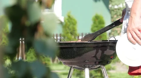 Man checking doneness of a BBQ meat. Handheld shot Stock Footage 68175641