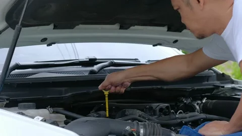 A man is checking the engine oil level of the car Stock Footage 135327586