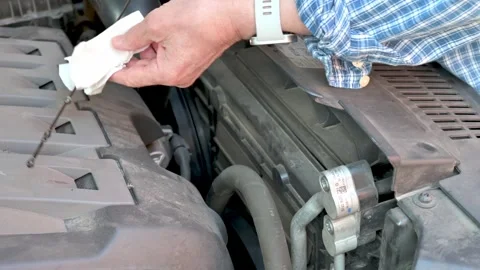 Man Checking Engine Oil Level on a Vehicle for Maintenance Stock Footage 312730833