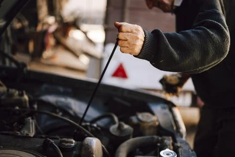 Man checking engine oil level in a garage 스톡 사진