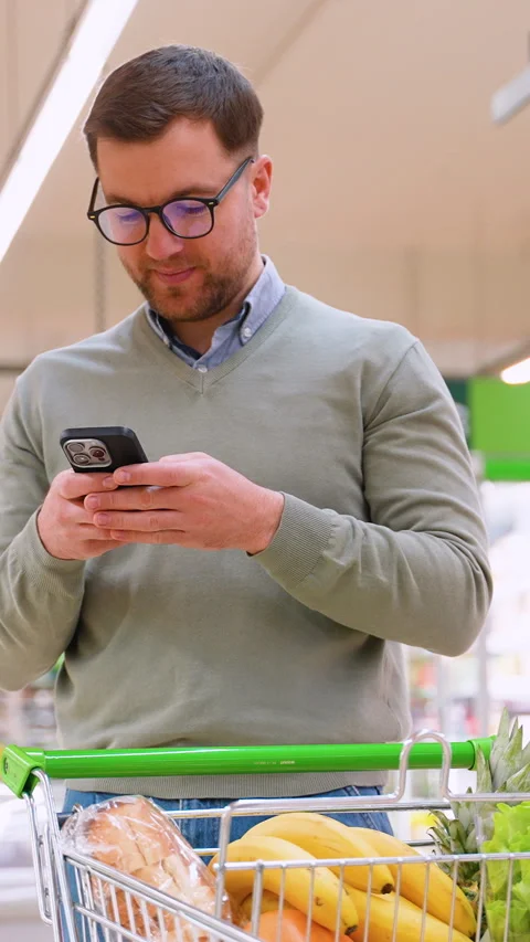 Man checking grocery list on phone while shopping Stock Footage 304089210