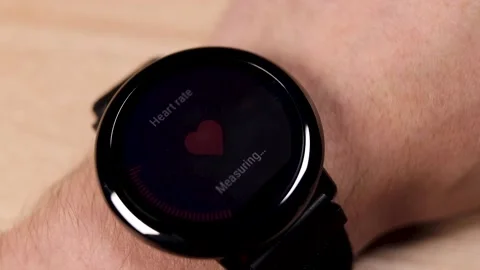 Man checking heart rate, measuring pulse with smart watch, fitness bracelet on w Video stock 224145229