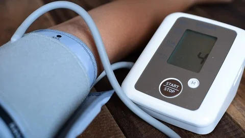 Man checking his blood pressure using blood pressure monitor or sphygmomanometer Stock Footage 104758479