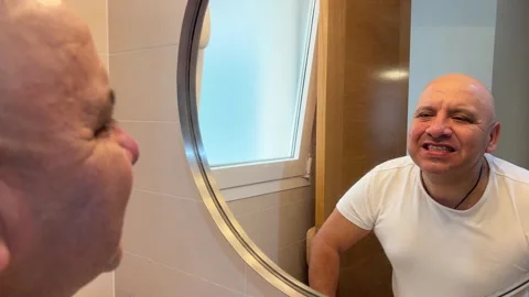Man checking his clean teeth in the bathroom mirror Stock Footage 333406212