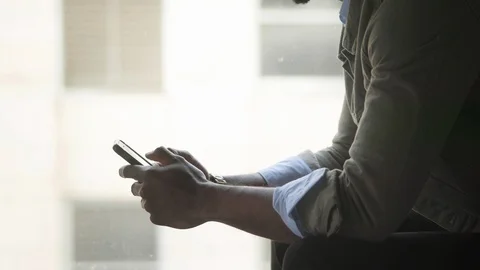 Man checking his mobile phone next to a window Stock Footage 112055679