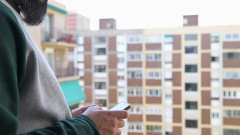 Man checking his smart phone on the balcony Stock-Footage 128966627