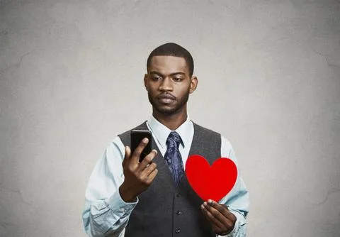 Man checking his smart phone, holding red heart Stock Photos