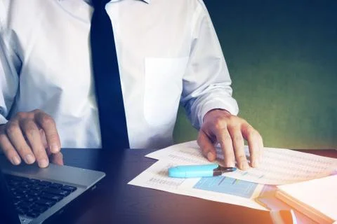 Man checking in laptop financial data and payment documents. Foto stock