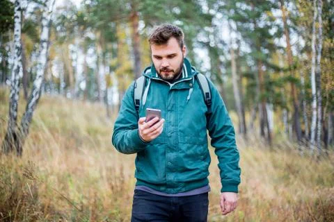Man checking map on phone while hiking Stock Photos