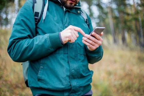 Man checking map on phone while hiking Stock Photos