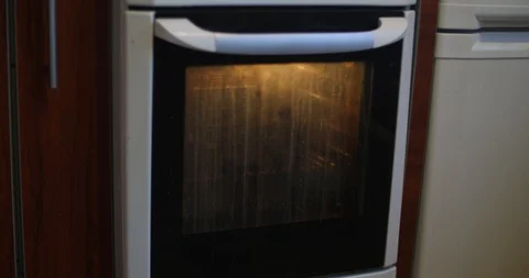 A man is checking the meat in the oven Stock Footage 86980106