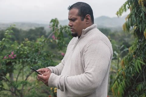 Man checking the mobile in the environment of nature happy, latino looking at Stock Photos