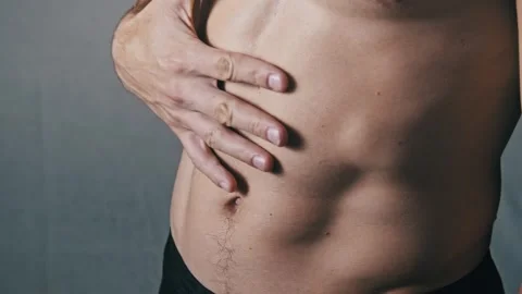 Man Checking the Muscle Tone of His Obliques and Abdomen Stock Footage 315410552