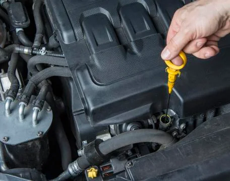 Man is checking the oil in the car engine Stock Photos