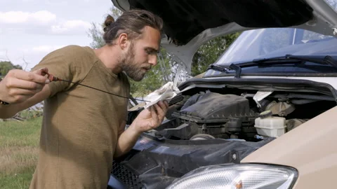 Man checking the oil level of a van engine outdoors Video stock 225904980