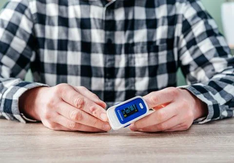 A man checking oxygen level at home with home oximeter, patient measuring the Stock Photos