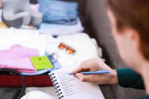 Man checking a packing list in a notebook during travel preparation for a s.. Stock Photos