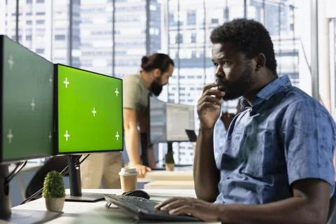 Man checking paperwork details on chroma key computer, solving tasks Foto stock