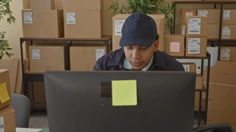 Man checking parcels and scanning labels at a computer desk surrounded by b.. Stock Footage 347849097