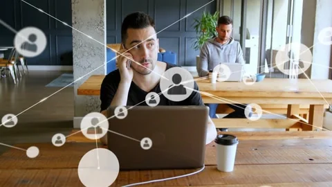 Man checking phone then calling, animated network icons expanding across laptop Stock Footage 332405635