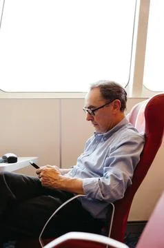 Man checking phone while seated on ferry Stock-Fotos