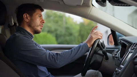 Man checking phone while sitting behind car steering wheel Stock Footage 340133846