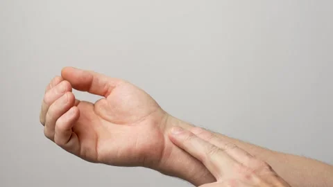 Man checking pulse with fingers on his wrist, close-up Video stock 261563090