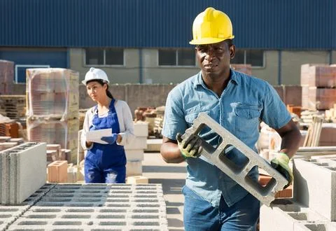 Man is checking quality of bricks in the open area of a construction store Foto stock