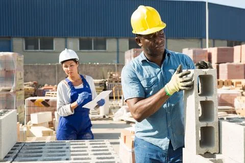 Man is checking quality of bricks in the open area of a construction store Foto stock