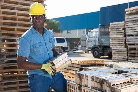 Man is checking quality of bricks in the open area of a construction store Stock Photos