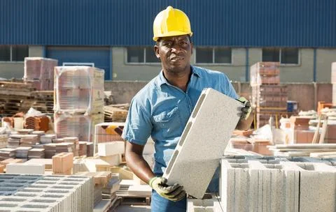 Man is checking quality of bricks in the open area of a construction store Foto stock