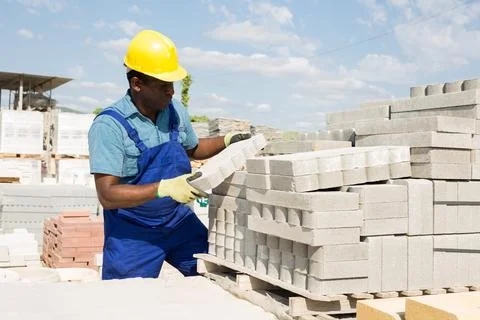 Man is checking quality of bricks in the open area of a construction store Stock Photos