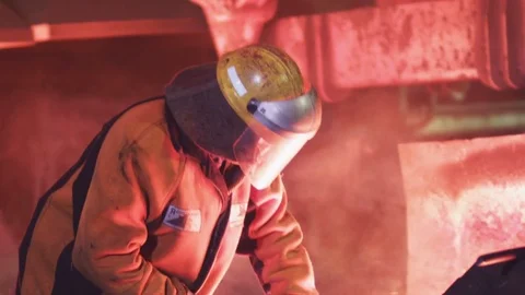 A man is checking the quality of molten metal Stock Footage 72611987