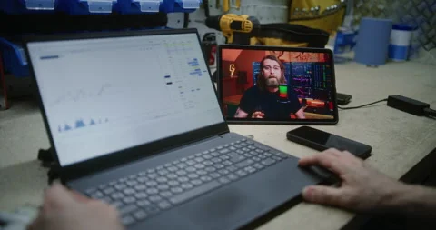 Man Checking Real-Time Stocks Using Laptop, Watching Online Trading Tutorial on Stock Footage 310138557