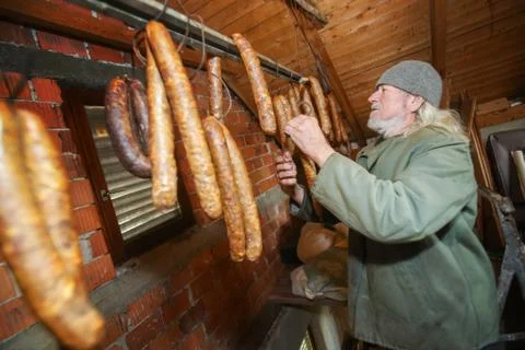 Man checking on sausages in attick Stock Photos