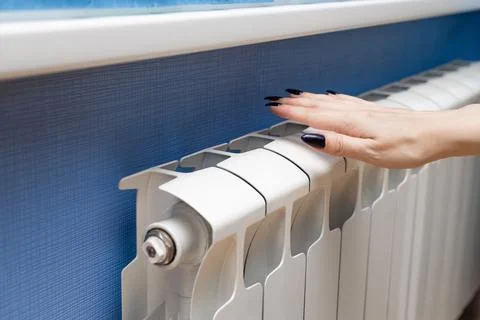 Man checking the temperature of a heating radiator. Foto stock