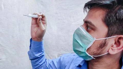 Man checking Temperature measurements using Thermometer. Stock Photos