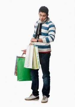 Man checking the time and carrying shopping bags Stock Photos