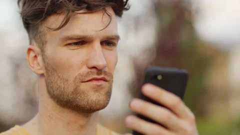 Man checking time on phone in park Stock Footage 132727138
