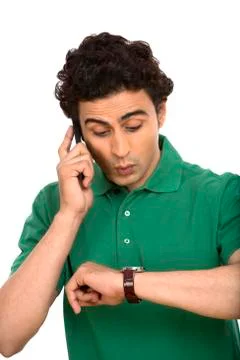 Man checking the time while talking on a mobile phone Stock Photos