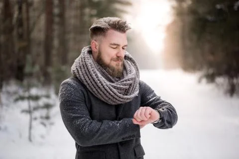 Man checking time in winter woods Foto stock