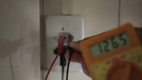 A man checking the voltage in a power outlet socket NBR 14136 using a multimer   Stock Footage 155605283