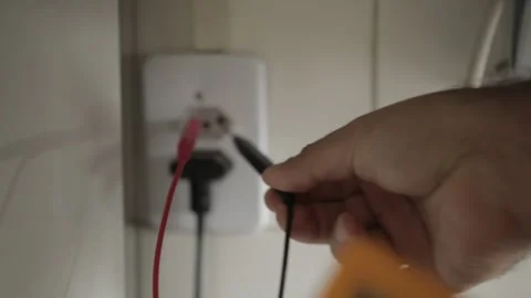 A man checking the voltage in a power outlet socket NBR 14136 using a multimer   Stock-Footage 155605381