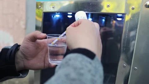 Man checking water quality at a public vending machine using a test strip. Analy Stock Footage 339879167