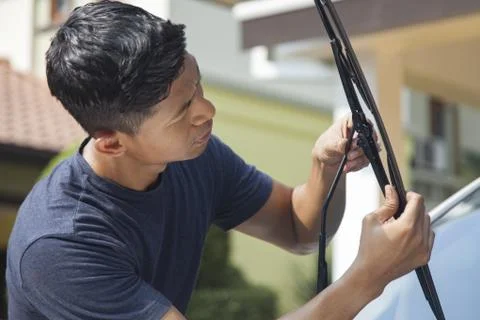 Man checking windshield wiper of his car Stock Photos