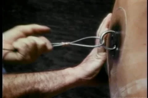 Man checking wire attached to back of stuntman's harness vest Video stock 25207548