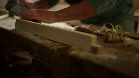 Man checking wood softness in studio. Unknown guy using sandpaper in carpentry Stock Photos