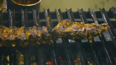 A man checks the degree of roasting the ribs on the grill Stock Footage 84252880