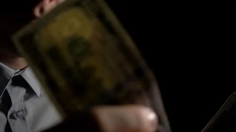 A man checks dollars for authenticity. A man sniffs dollars. Clous up. 4k slow Stock Footage 95962241